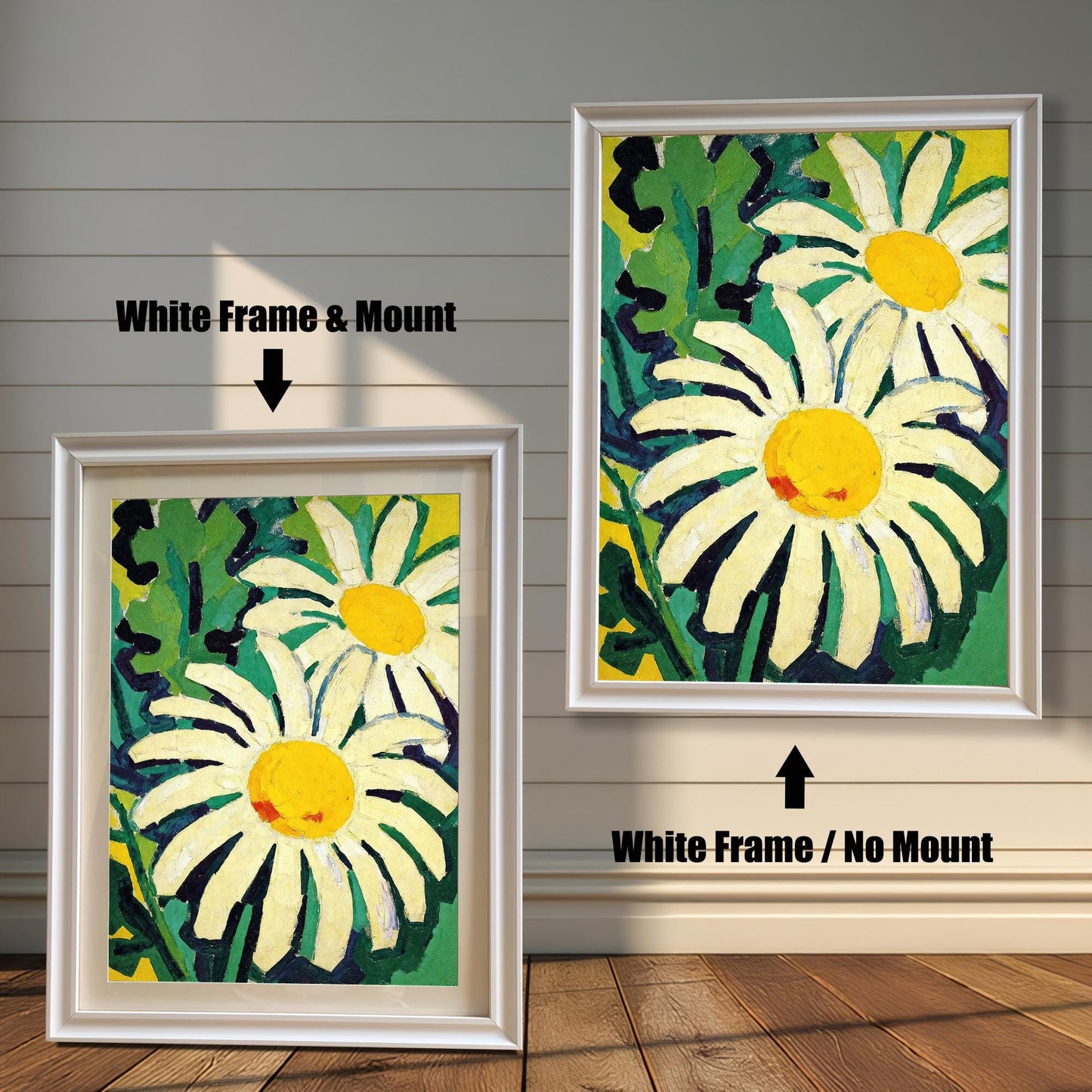 A framed painting of two daisies is shown in two styles against a wooden wall. One has a white frame with a white mount, the other is a larger size with the same frame, but no mount.