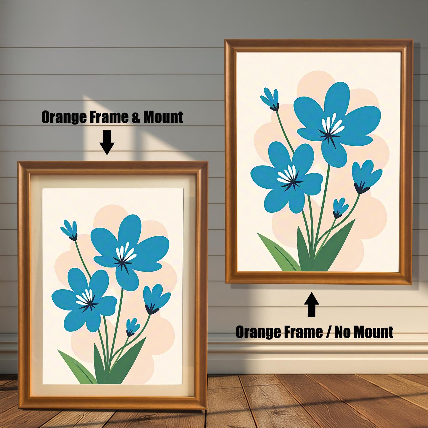 A side-by-side comparison of two orange-framed prints of a blue flower painting. The print on the left is smaller with a mount (matting), while the larger one on the right has no mount.