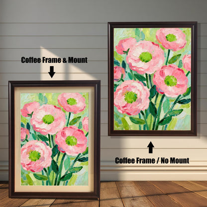 A painting of pink flowers in a coffee-colored frame, shown with and without a white mat, displayed against a rustic wood-paneled wall.