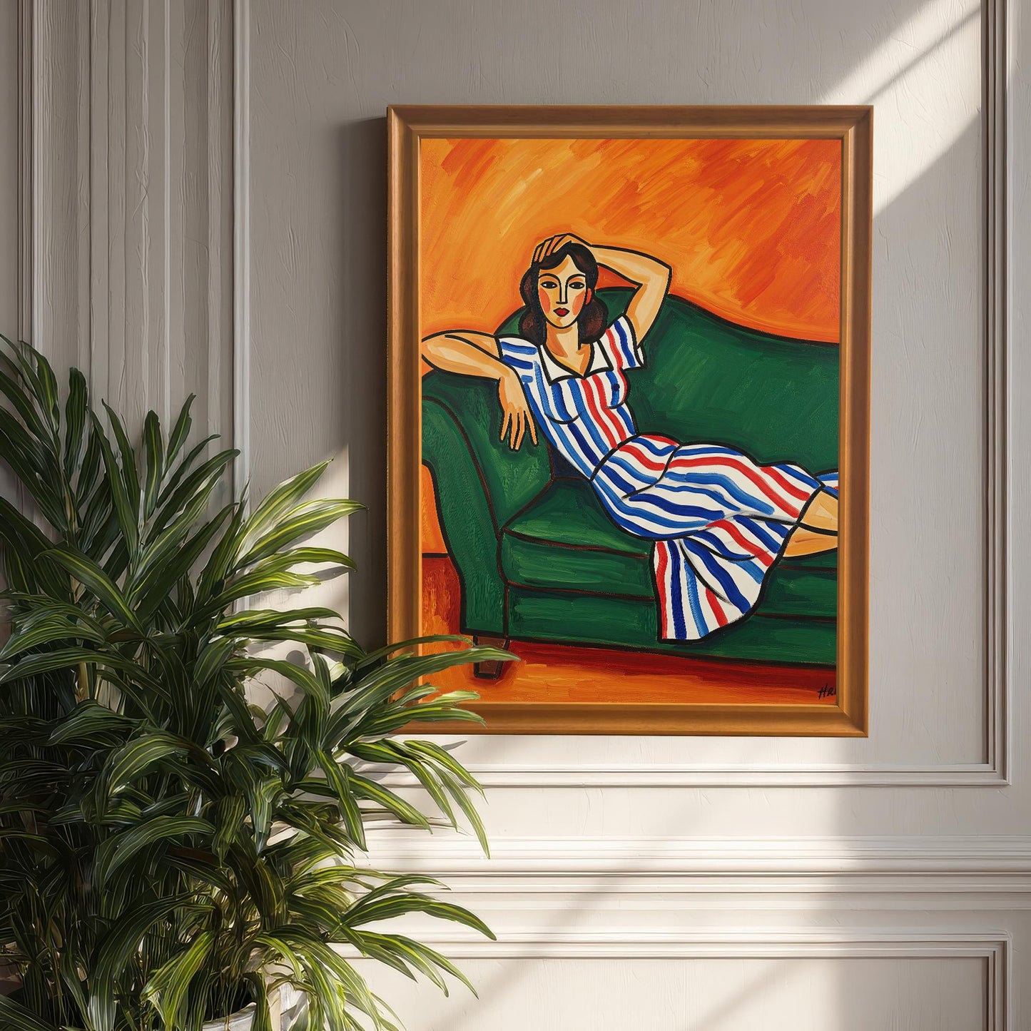 An orange-framed art print of a woman in a striped dress, propped against a light-colored wall with wainscoting. A large, leafy houseplant is in the foreground.