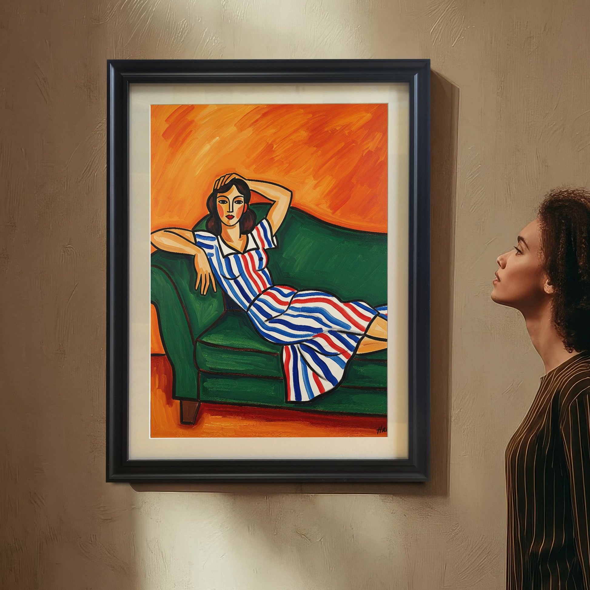 A woman with curly hair looks up at a black-framed art print of a seated woman in a striped dress. The print hangs on a textured wall.