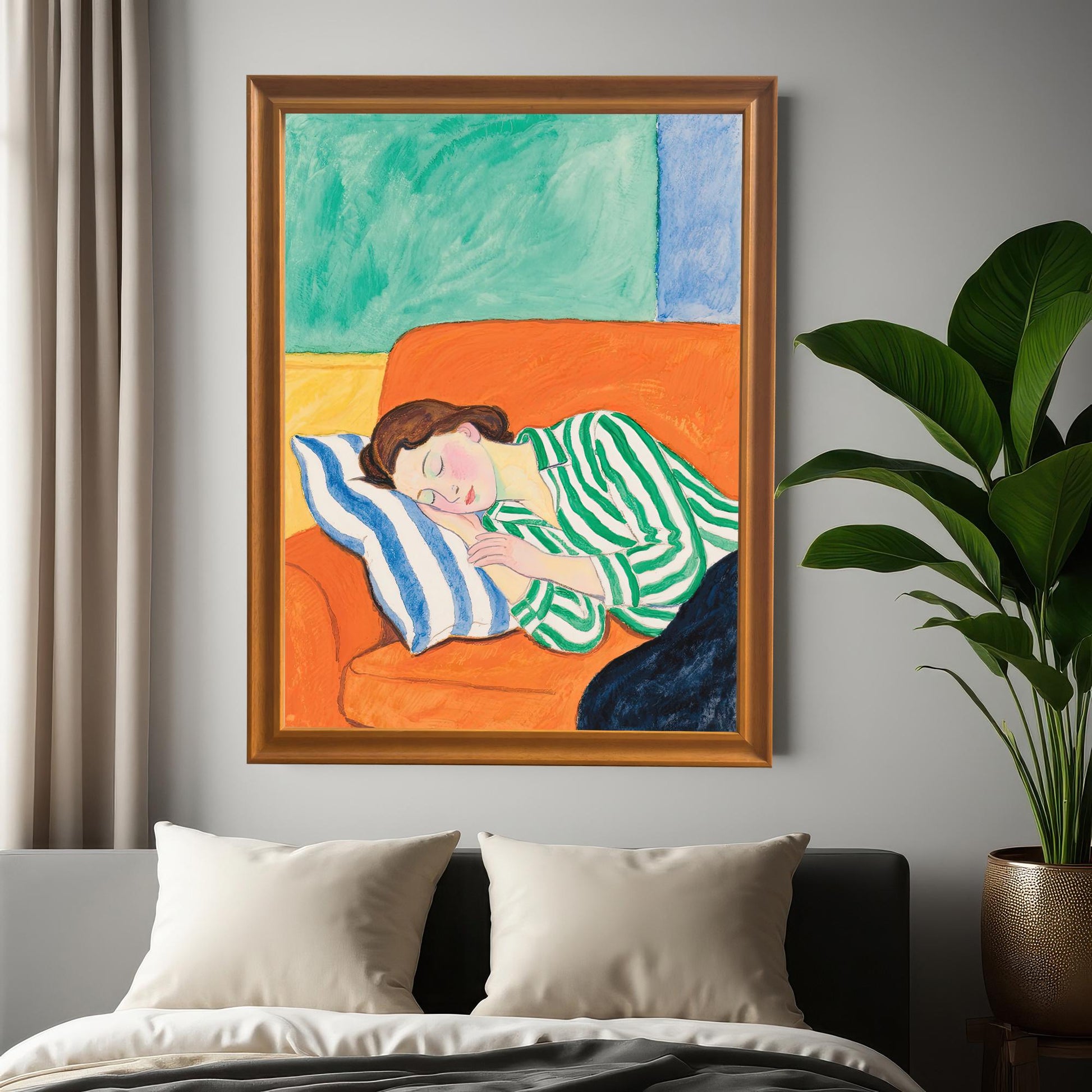 A framed painting of a woman sleeping on an orange sofa hangs on a gray wall above a bed. The frame is a light brown wood with a gold inner trim.