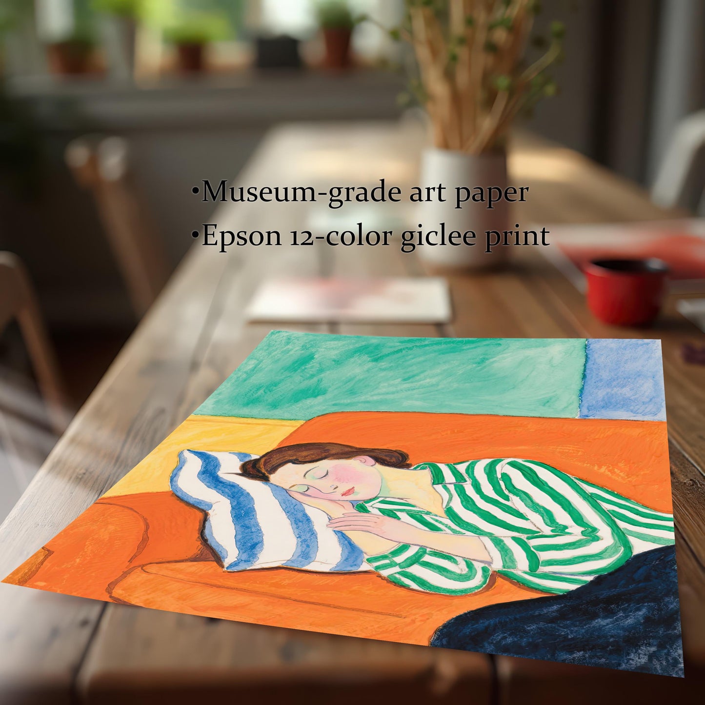 A close-up view of an unframed art print, showing a painting of a woman sleeping on an orange sofa. The print is on a wooden table, and the text mentions museum-grade art paper.