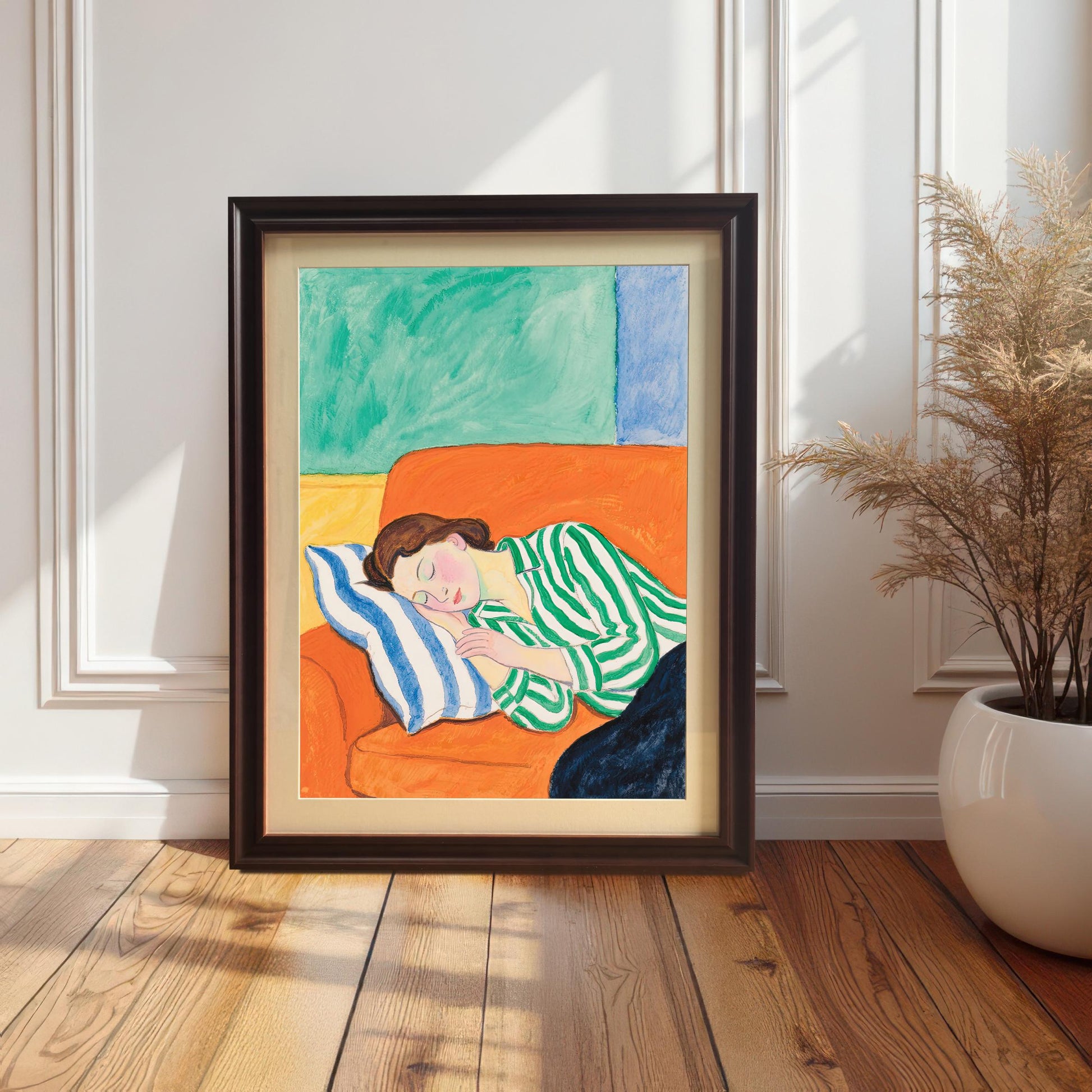 A painting of a woman sleeping on an orange sofa leans against a white paneled wall. The painting is in a dark brown wooden frame.