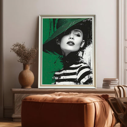 A framed print of a woman in a green hat and striped shirt. The frame is white with a thin inner border and the print is propped up on a bench-style table behind a large brown leather ottoman.