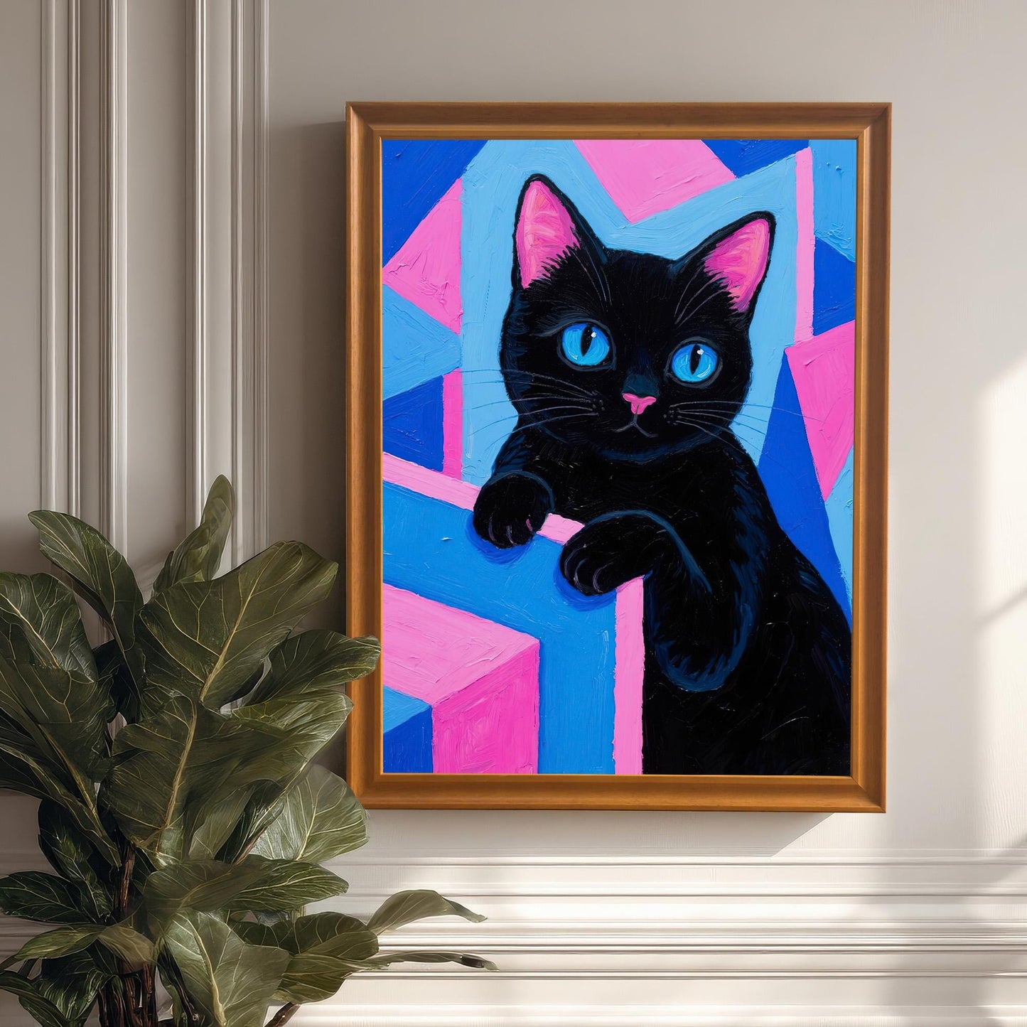 A framed black cat art print in an orange/wood frame, hanging on a white wall next to a large green houseplant.