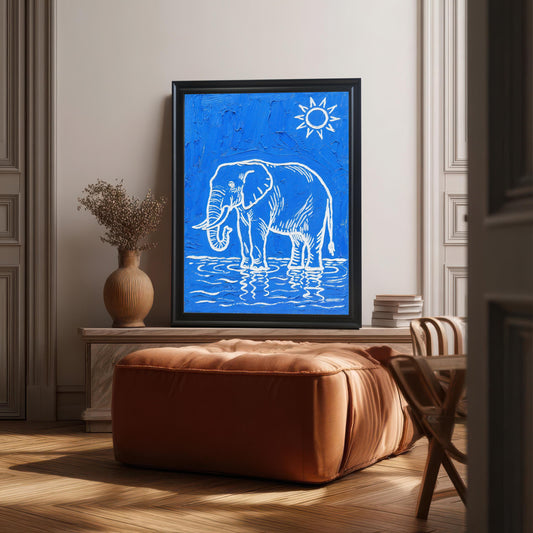 A large framed black and blue elephant print is propped on a low console behind a leather ottoman in a well-lit living space.