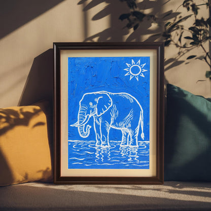 A framed blue and white elephant print stands between a yellow and a teal pillow in a sunlit room.