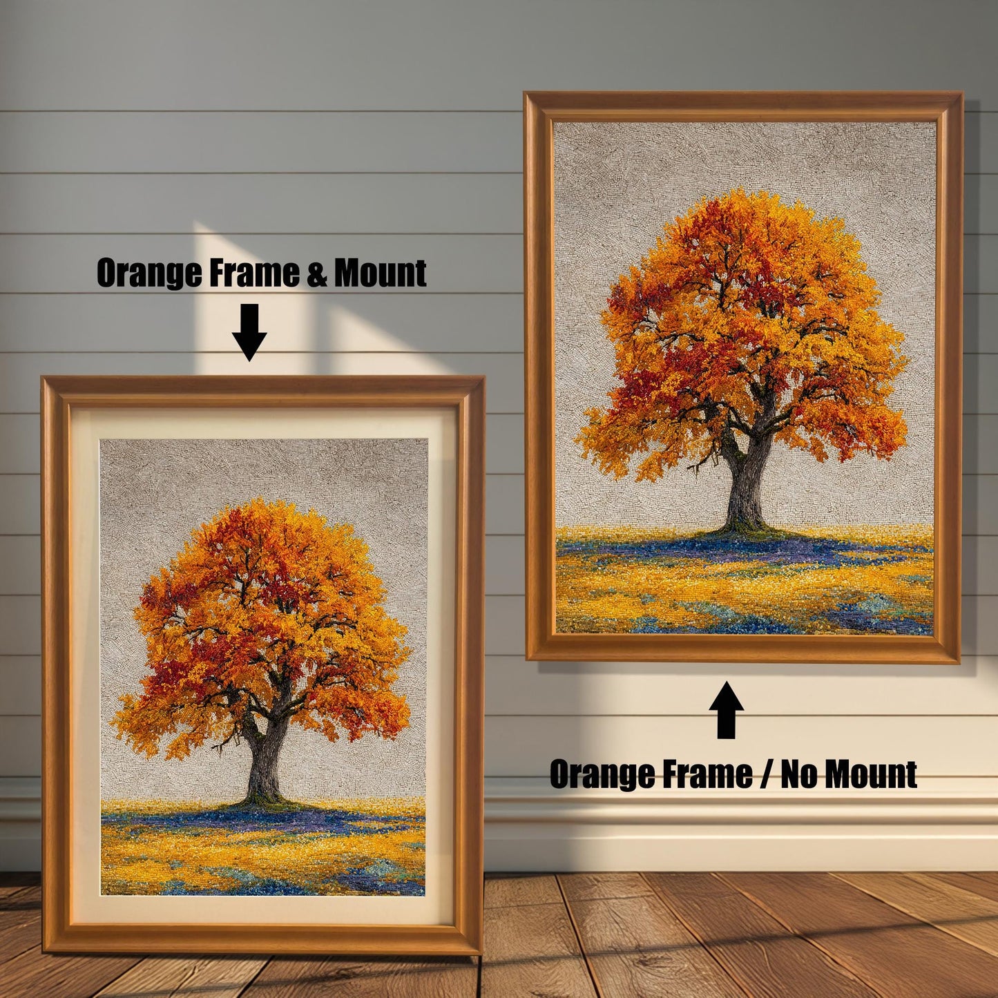Two framed art prints of an autumn tree are on a wooden floor. The print on the left is in an orange frame with a mount, and the one on the right is in an orange frame without a mount.