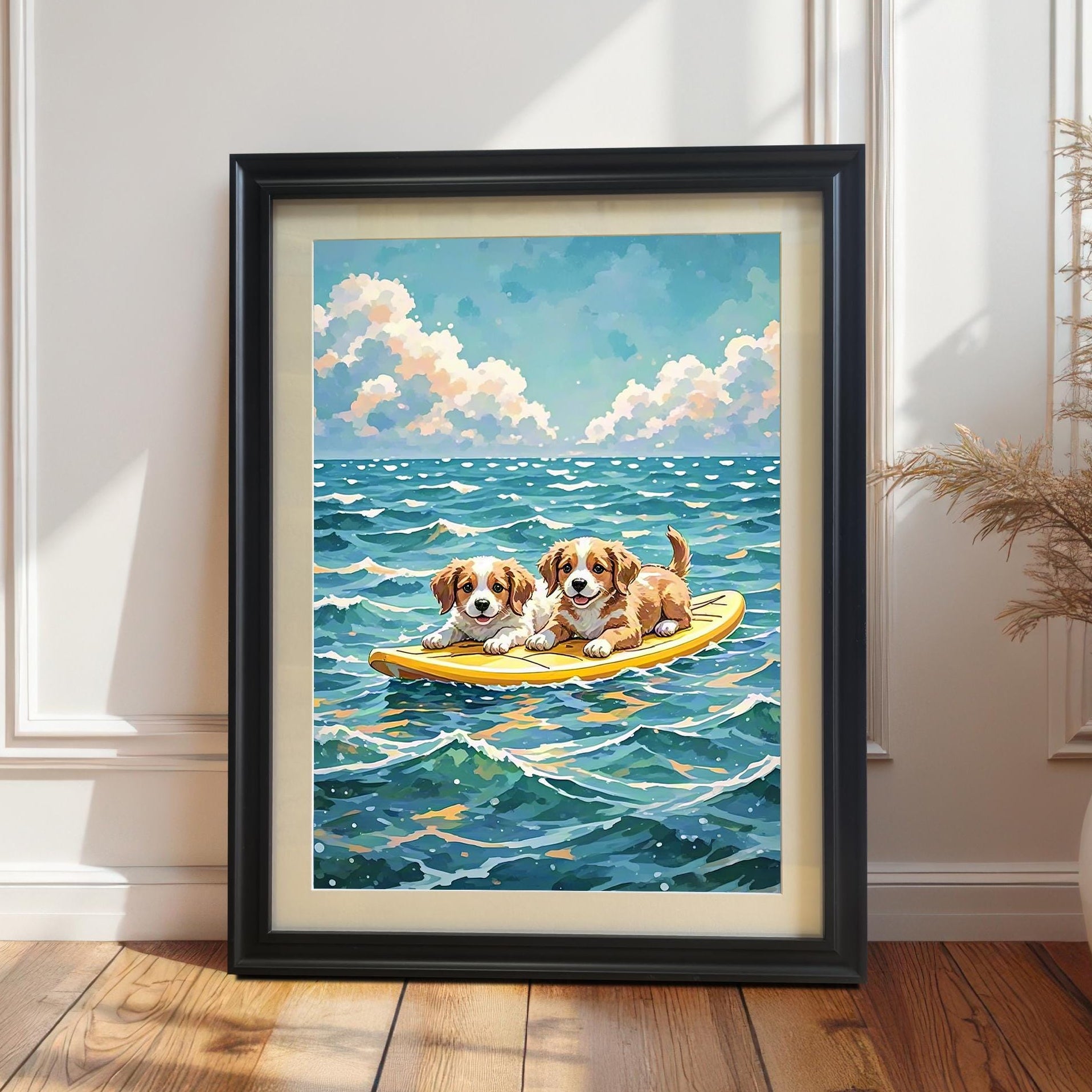 A framed art print of two puppies on a surfboard in the ocean. The black-framed picture is leaning against a white wainscoted wall next to a large potted plant.