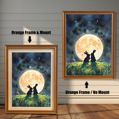 Two framed prints of rabbits under a moon. The one on the left has an "Orange Frame & Mount," and the right has an "Orange Frame / No Mount."