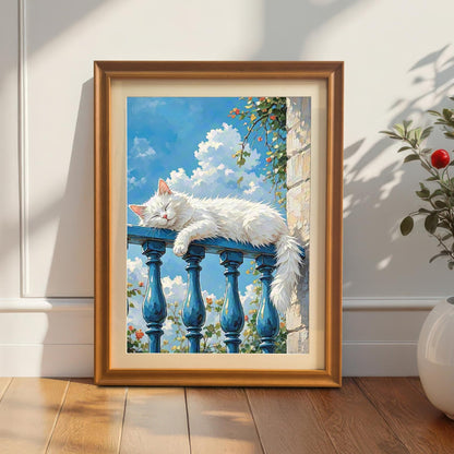 An orange-framed art print of a white cat sleeping on a blue balcony railing, leaning against a white wall on a hardwood floor next to a potted plant.