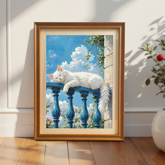 An orange-framed art print of a white cat sleeping on a blue balcony railing, leaning against a white wall on a hardwood floor next to a potted plant.