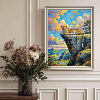 Framed wall art of a leopard on a cliffside, hanging on a white paneled wall with a vase of flowers on a table below it.