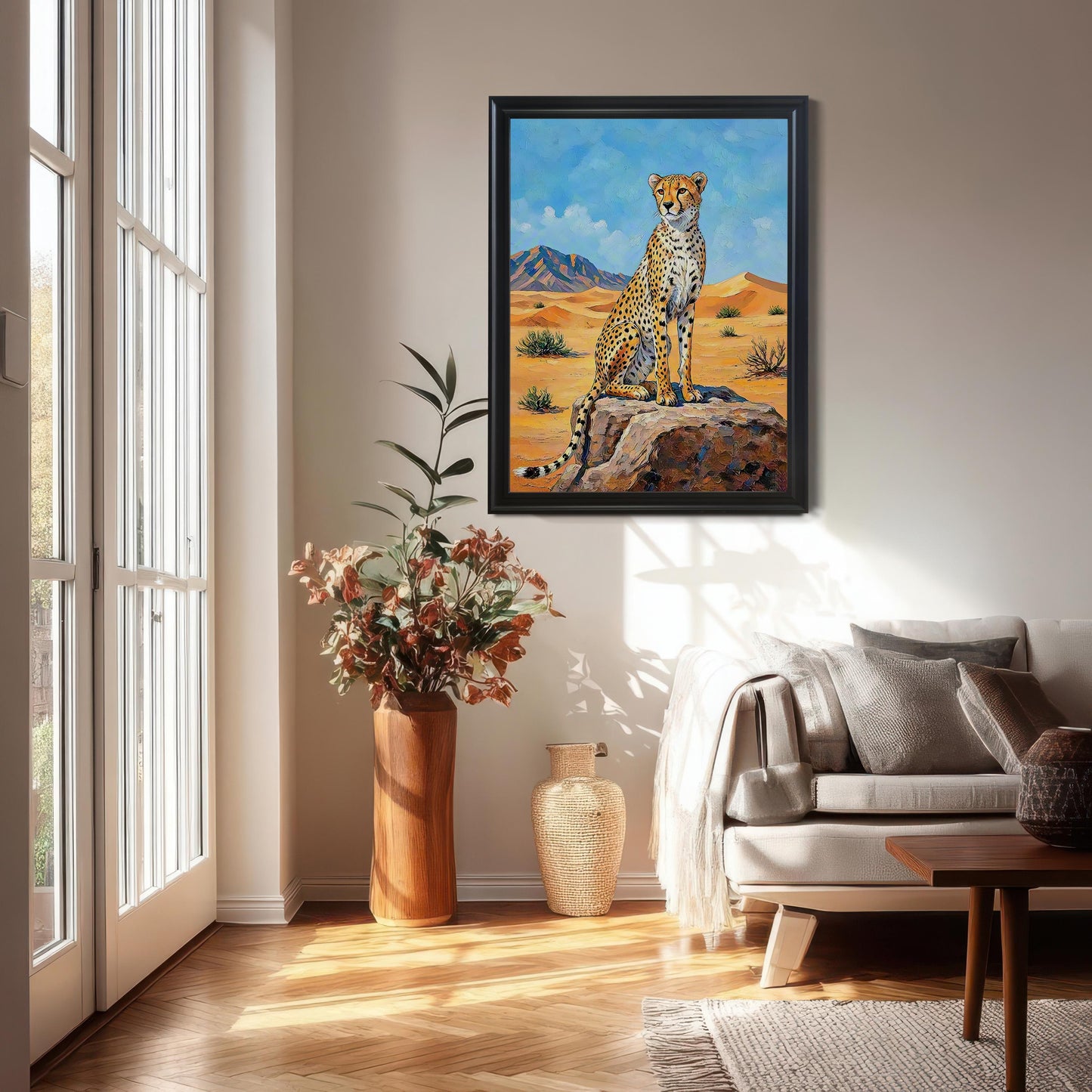 Framed wall art of a cheetah in a desert landscape, hung in a sunlit living room above a couch.