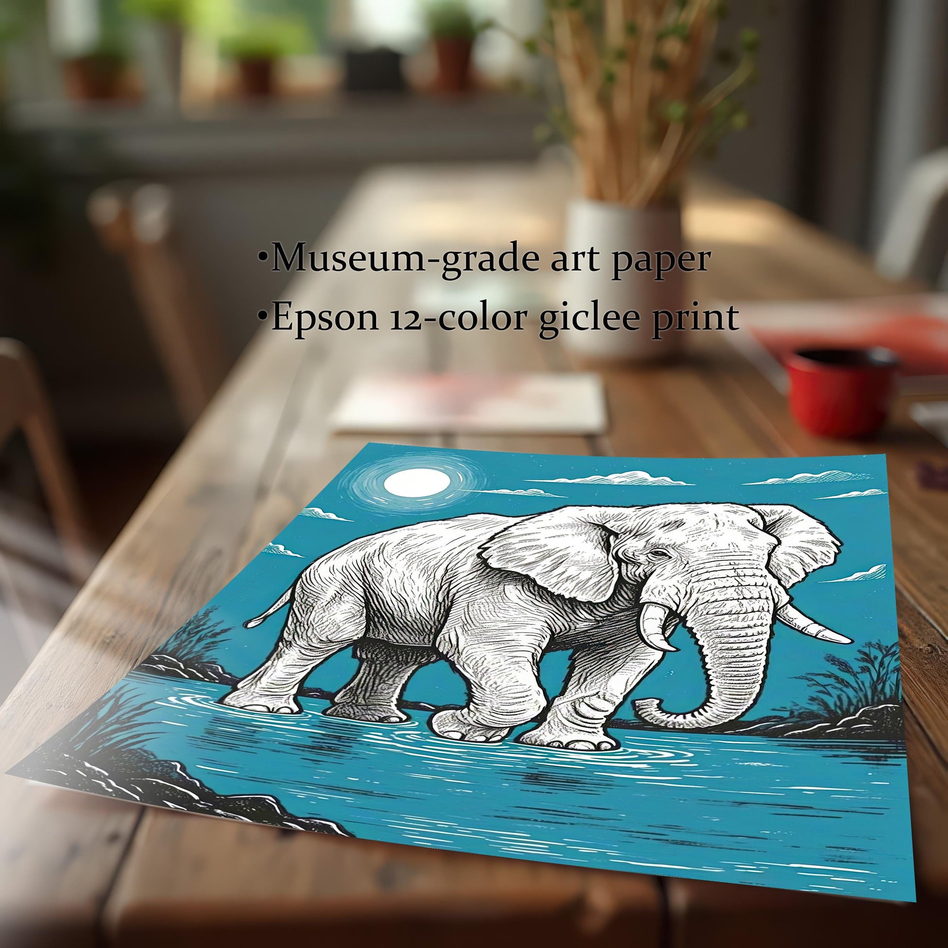 A close-up of a print of a painting of an elephant standing in water, with a full moon in a blue sky, lying on a wooden table.