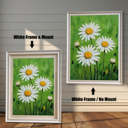 A side-by-side comparison of two framed daisy prints. The one on the left has a white frame and a cream-colored mat. The one on the right has a white frame with no mat.