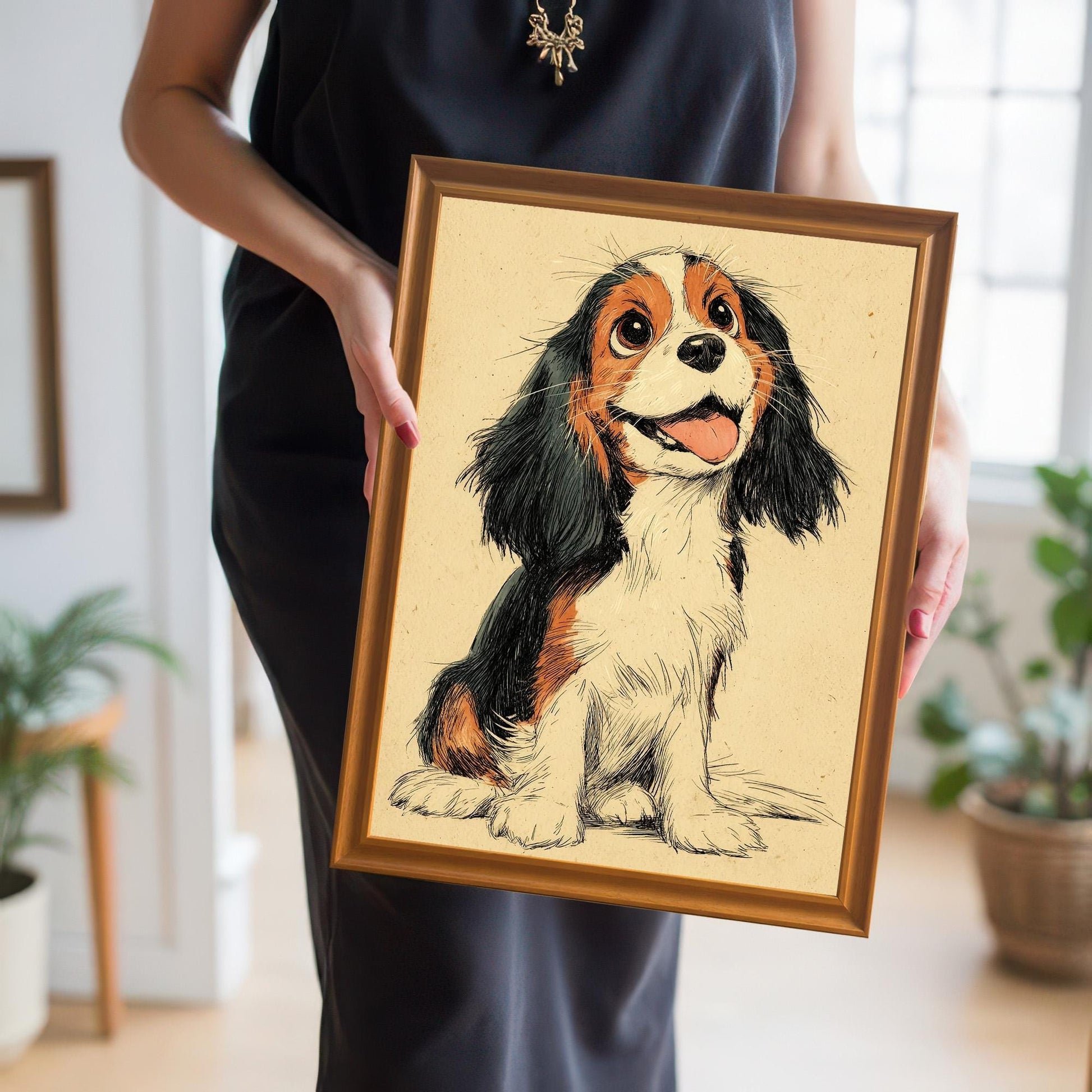 A woman in a black dress holds a framed drawing of a Cavalier King Charles Spaniel puppy with a happy expression.
