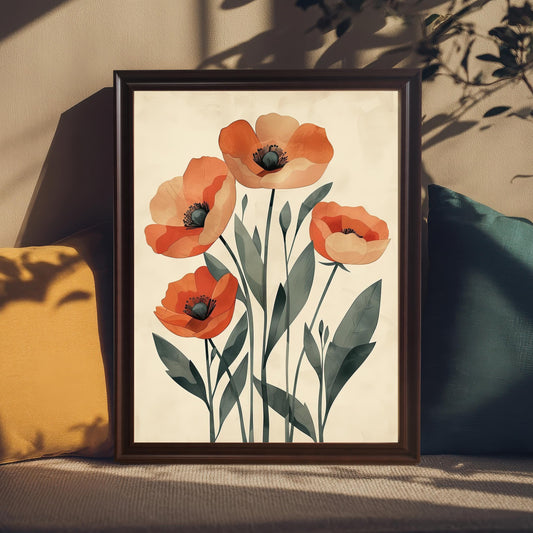 A framed art print of five orange poppies on a pale background, with a coffee-colored frame, propped on a couch between two pillows.