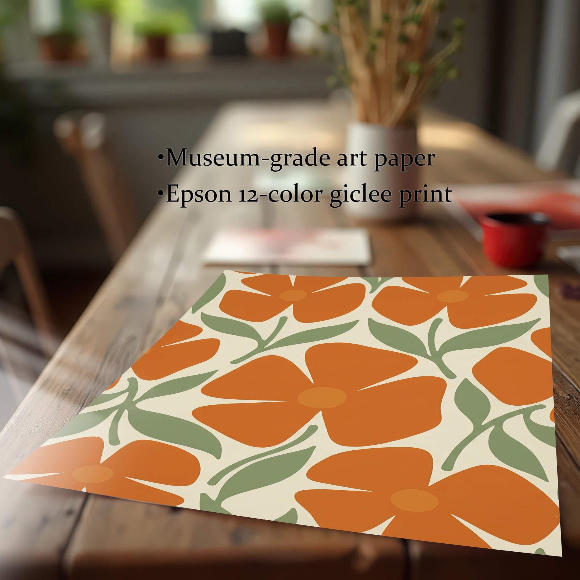A flat art print with a repeating pattern of orange flowers and green leaves on a wooden table, with text describing it as "museum-grade art paper" and an "Epson 12-color giclee print."