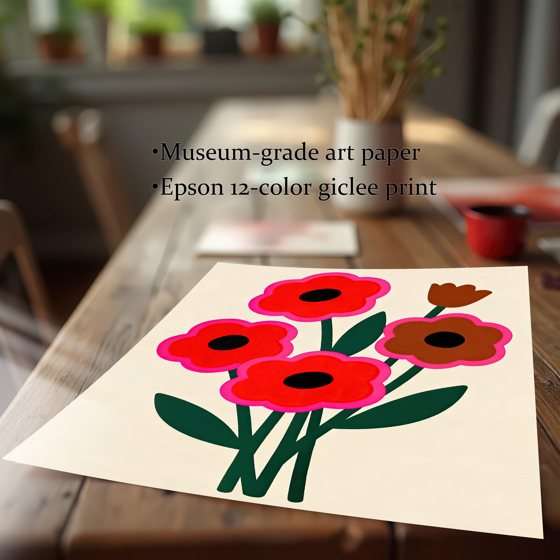 A flat lay of an unframed abstract floral print with red and brown flowers sits on a long wooden dining table.