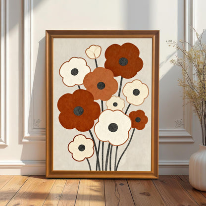 A framed abstract floral painting with brown and white flowers stands on a light wood floor, leaning against a white wainscoting wall with a white vase nearby.