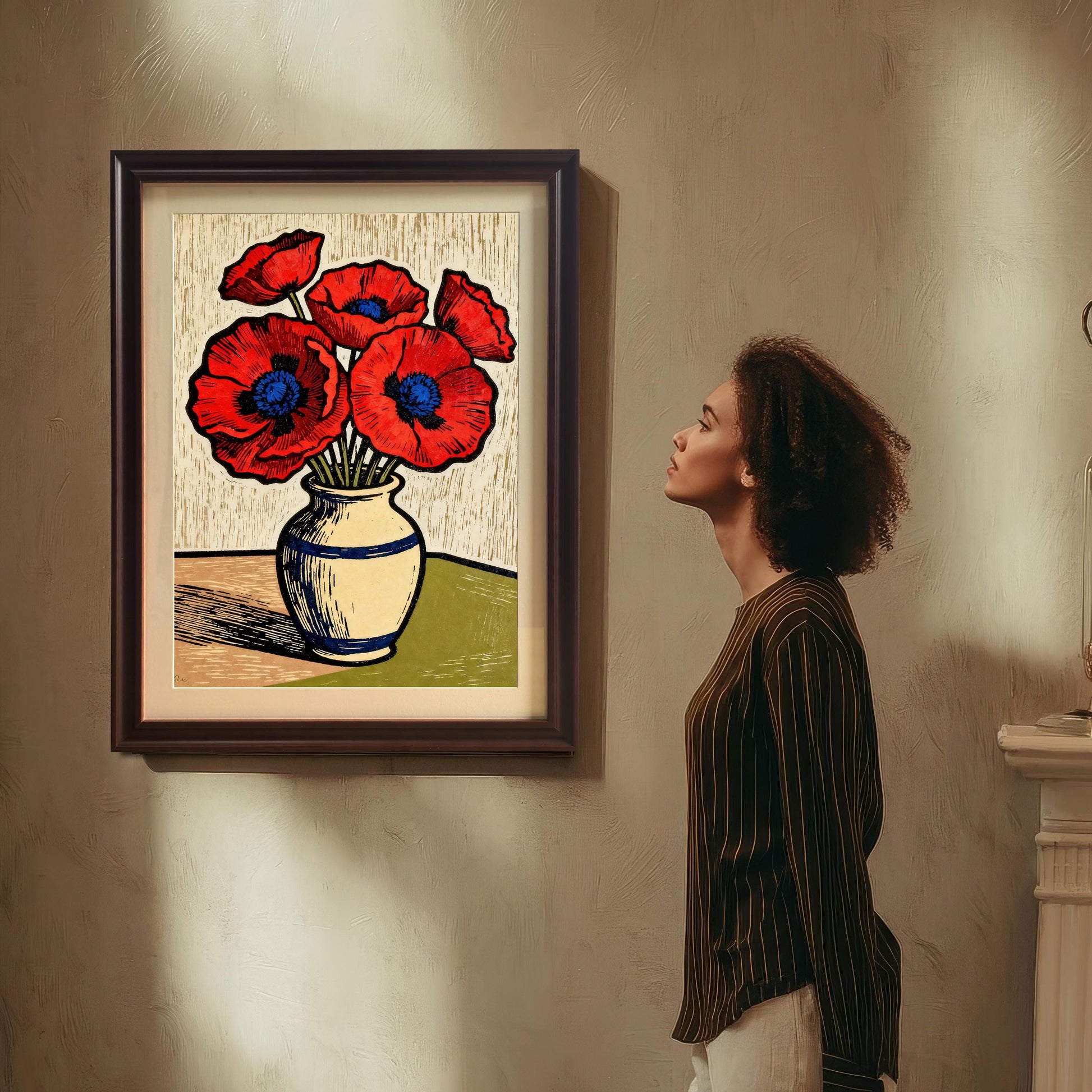 A woman with curly hair looks at a large framed art print of a vase of red poppies on a wall, suggesting appreciation and contemplation of the artwork.