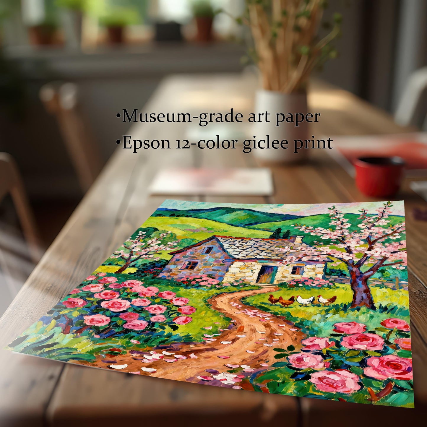 A close-up, angled view of an unframed art print of a cottage and rose garden lying on a wooden table. Text overlay highlights "Museum-grade art paper" and "Epson 12-color giclee print."