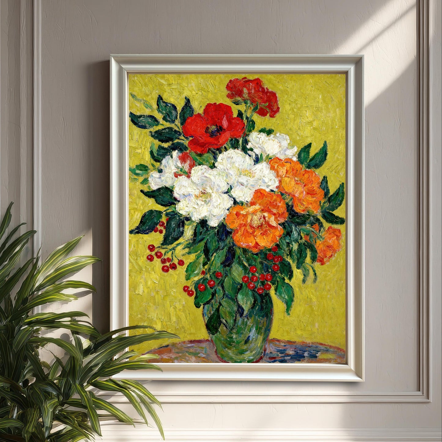 A framed painting of red, white, and orange flowers in a green vase, hanging on a gray paneled wall next to a large houseplant.