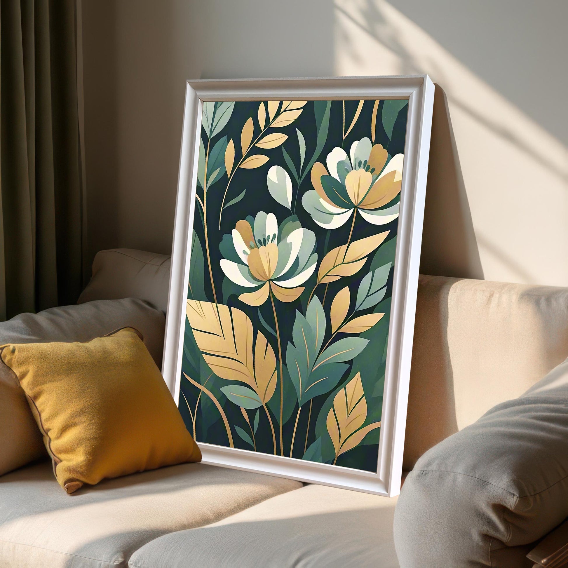 A framed print of white and gold flowers with green leaves leaning against a light-colored couch with a yellow pillow in a sunlit room.
