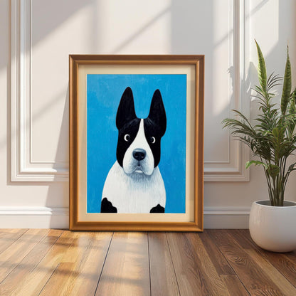Framed painting of the black and white dog on a bright blue background, in an Orange/Gold frame leaning against a white wainscoting wall next to a tall potted snake plant on a wooden floor, with sunlight casting sharp shadows.
