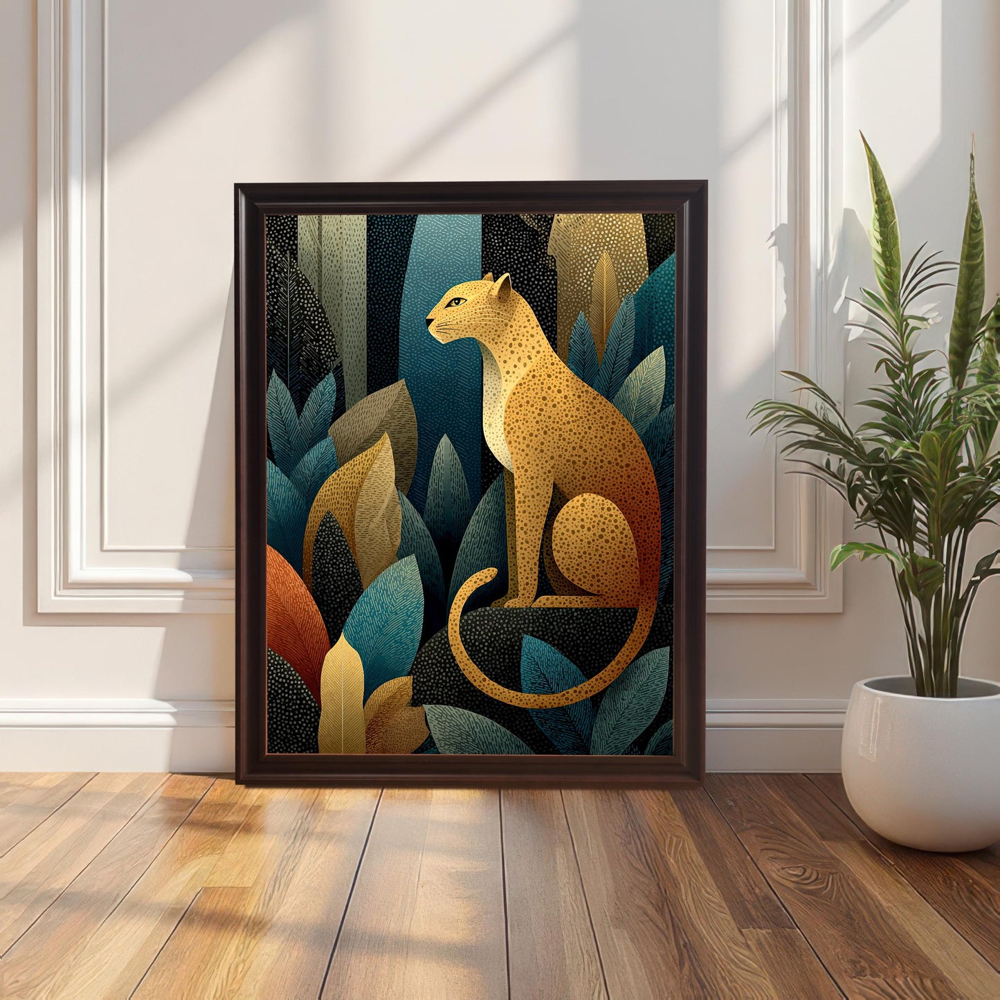 A framed art print of a golden leopard sitting among stylized jungle leaves, shown with a dark brown frame leaning on a wood floor next to a white wall panel and a potted snake plant.