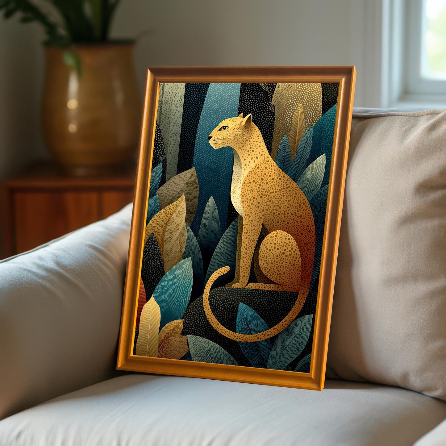 A close-up view of the leopard art print with a light orange-gold frame, resting on a white, textured sofa in a sunlit room.