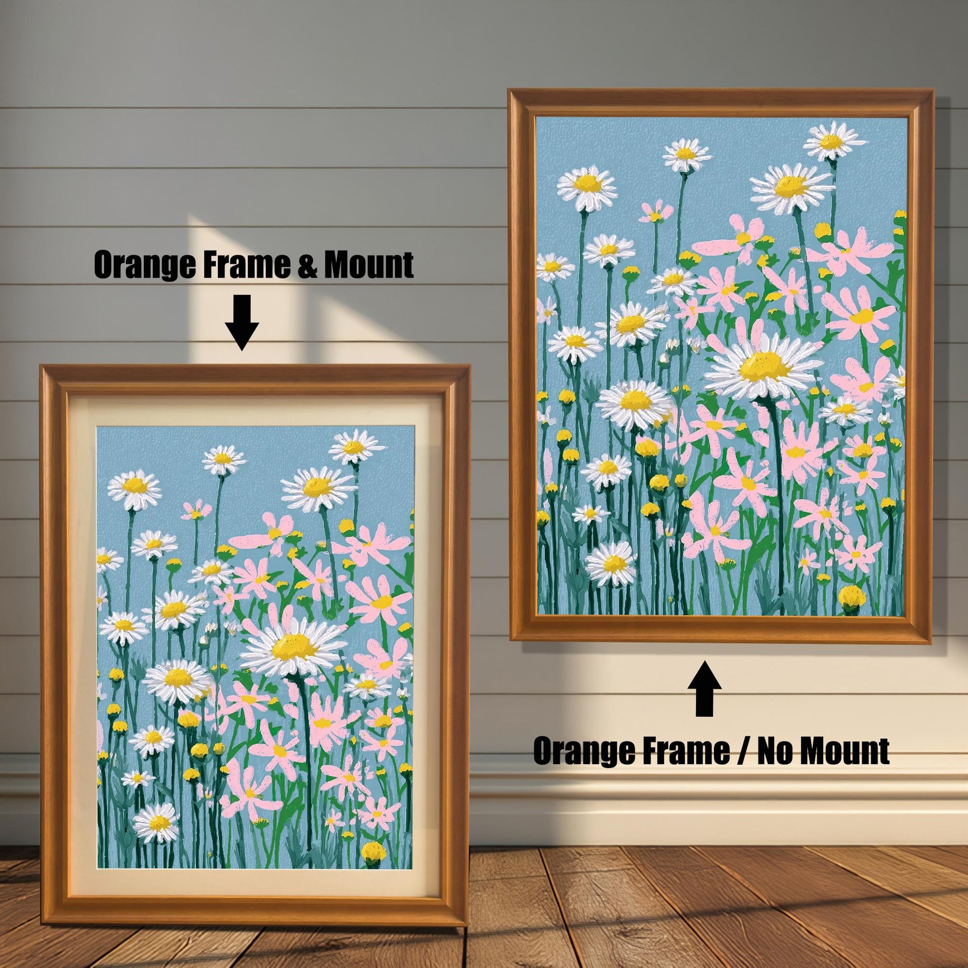 A framed art print of the daisy field illustration, shown in two options with an Orange Frame: one on the right with No Mount, and one on the left with a Mount (a light-colored mat).