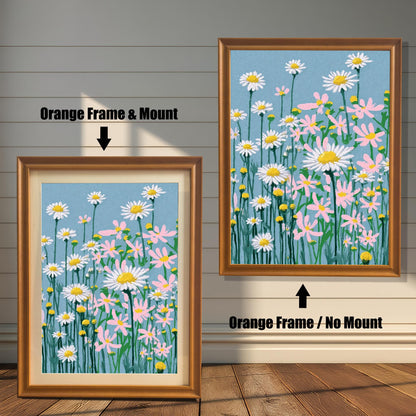 A framed art print of the daisy field illustration, shown in two options with an Orange Frame: one on the right with No Mount, and one on the left with a Mount (a light-colored mat).