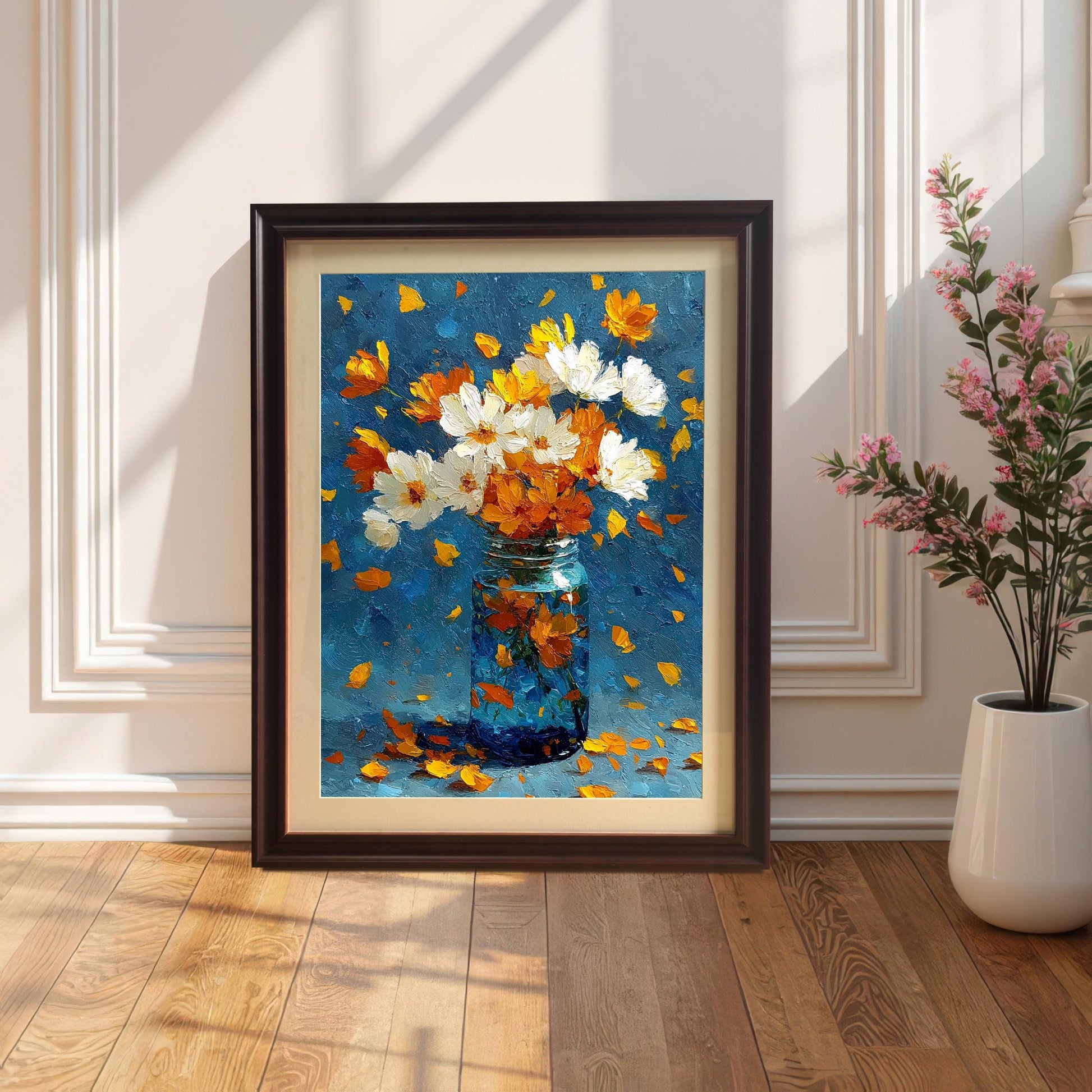 Oil painting of white and orange flowers in a blue glass jar, framed in a Coffee (dark brown) frame with a mount. The frame leans against a white wainscoted wall on a wood floor, with strong sunlight casting shadows.