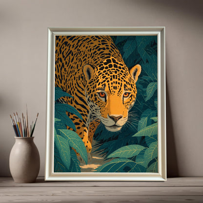 Artwork of a jaguar stalking through dark green jungle leaves, framed in a White frame (no mount). The framed art leans on a wooden surface next to a neutral-colored vase holding several paintbrushes.
