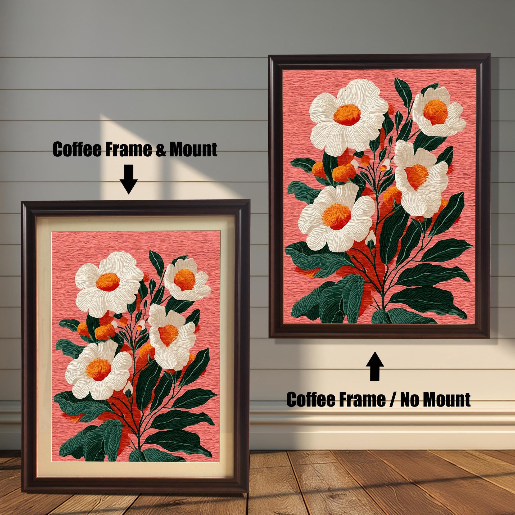 Two versions of a floral print against a rustic wooden wall. The print features white flowers with orange centers and dark green leaves on a textured salmon-pink background. On the left, a framed print with a Coffee (dark brown) frame and a visible beige mount (mat). On the right, a framed print with a Coffee frame and no mount.