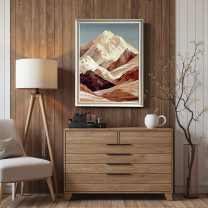 Framed print of a mountain landscape art in a wood veneer or marquetry style, hanging above a light wood dresser. The background wall is vertical wood paneling. The frame is a thin silver or light metallic color and includes a white mount (matting). A tripod floor lamp and a decorative branch in a vase flank the dresser.