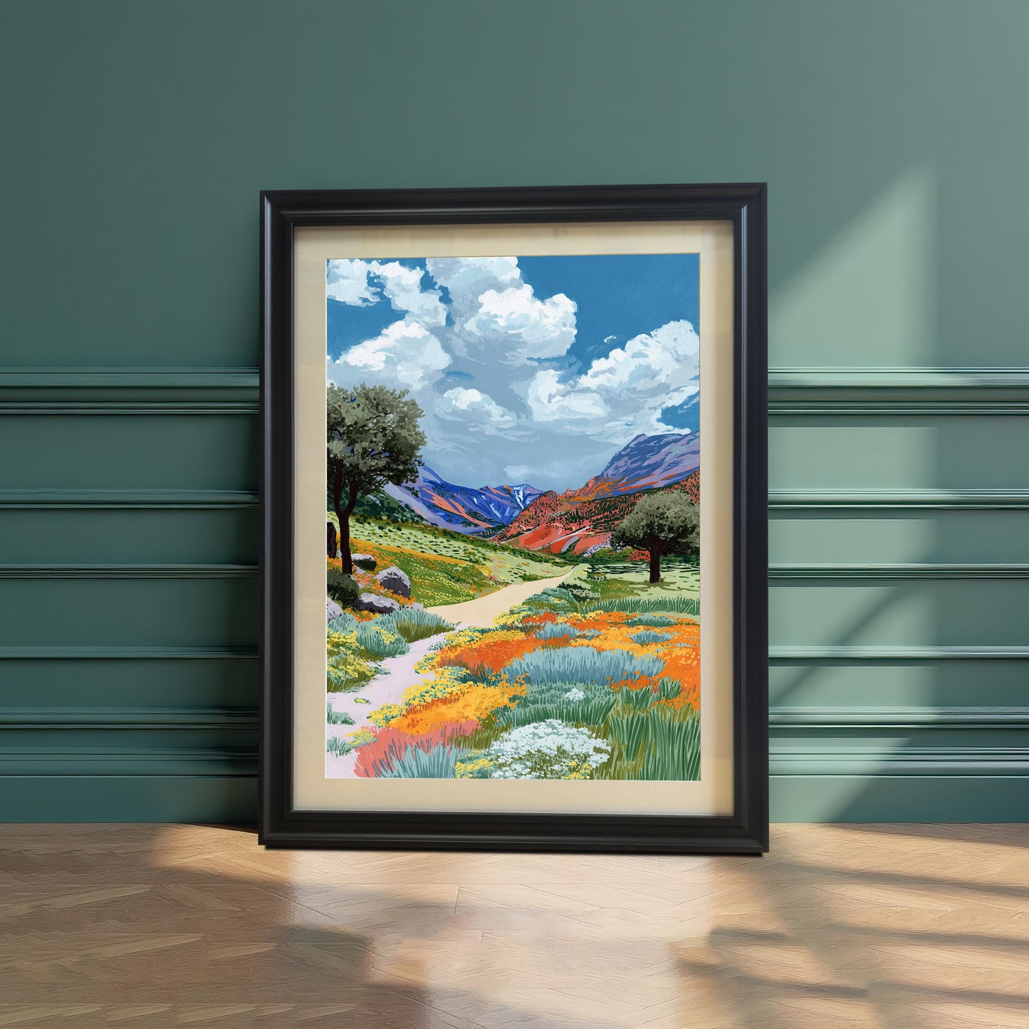 A colorful painting of a path winding through a field of orange and yellow wildflowers, framed in a Black frame with a mount, leaning on a hardwood floor against a decorative dark green paneled wall.