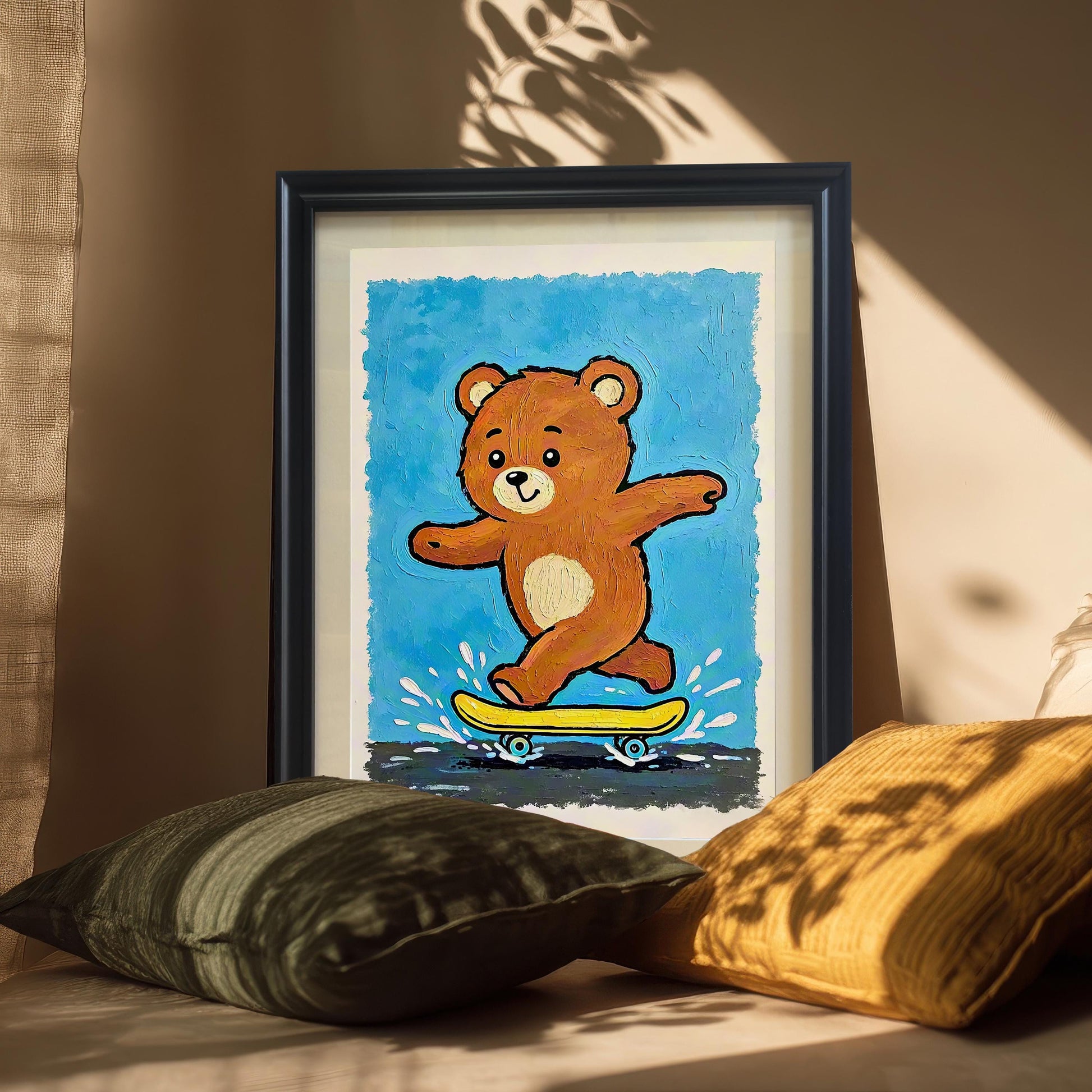A framed art print of a bear skateboarding is propped on a surface between two pillows, with sunlight casting shadows across the room. The frame is black with a white mat.