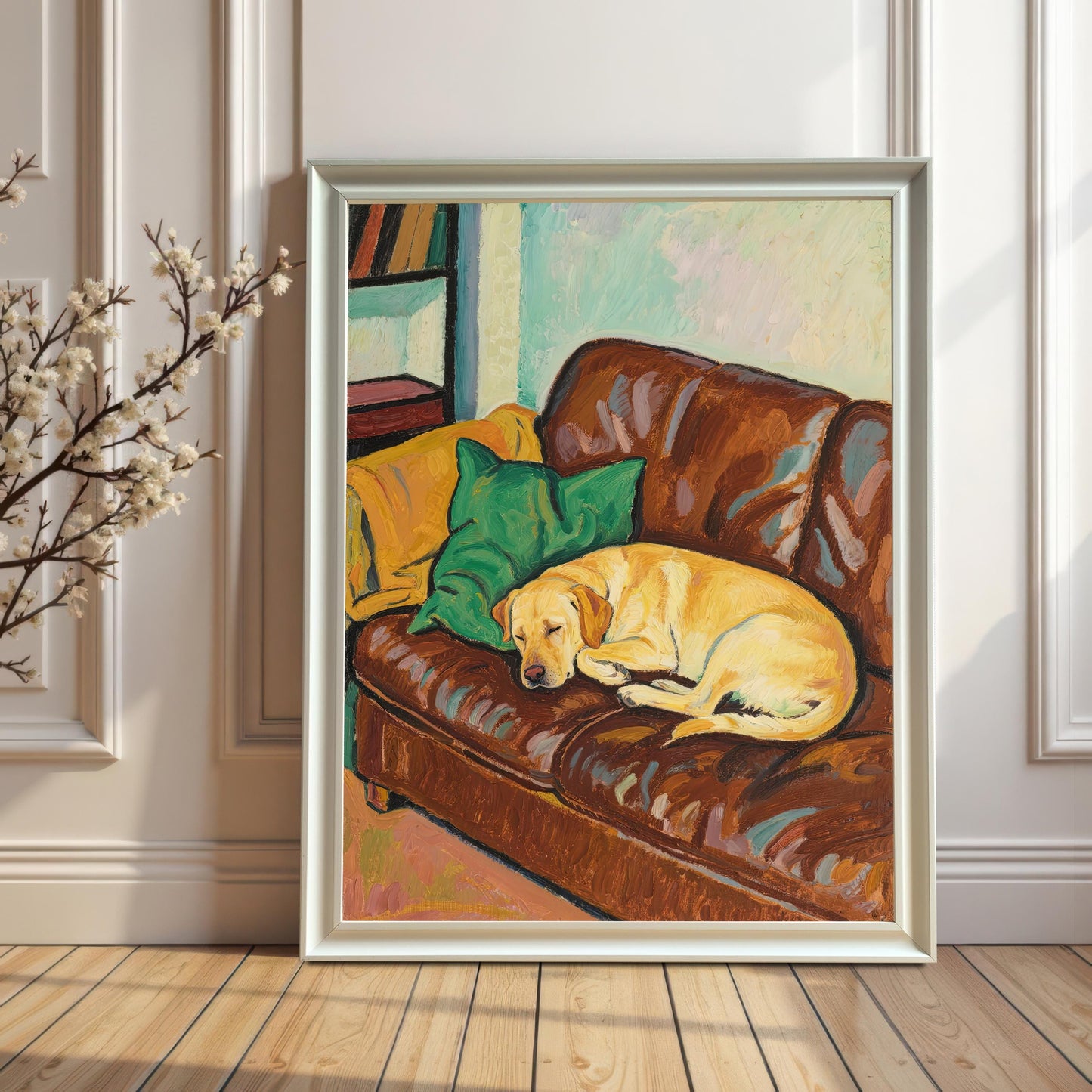 A white-framed art print of an oil painting featuring a yellow Labrador sleeping on a brown leather couch with pillows, leaning against a white paneled wall.