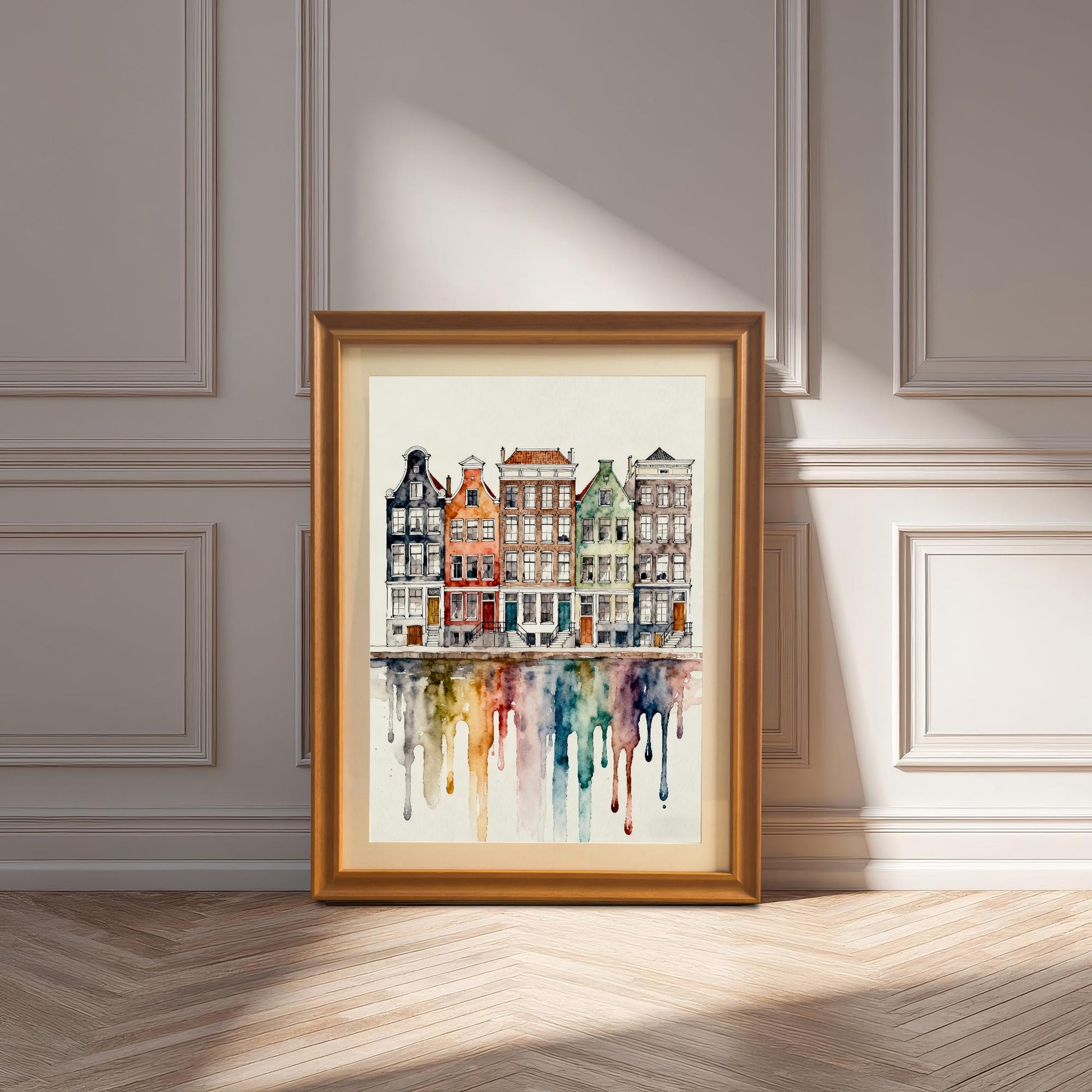 Watercolor print of colorful canal houses with a dripping reflection, displayed in a natural wood/orange frame leaning on a light wooden floor against a white paneled wall.