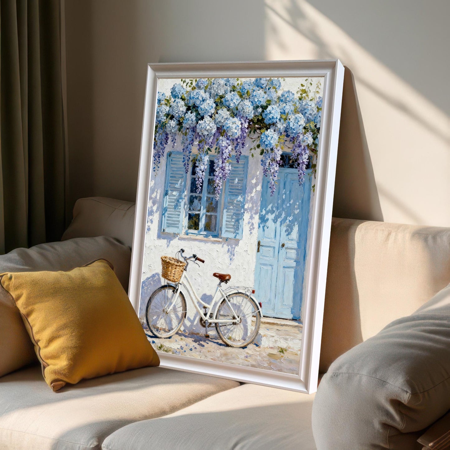 Framed print in a White frame leaning on a light-colored sofa next to a yellow pillow, showing sunlight and shadows.