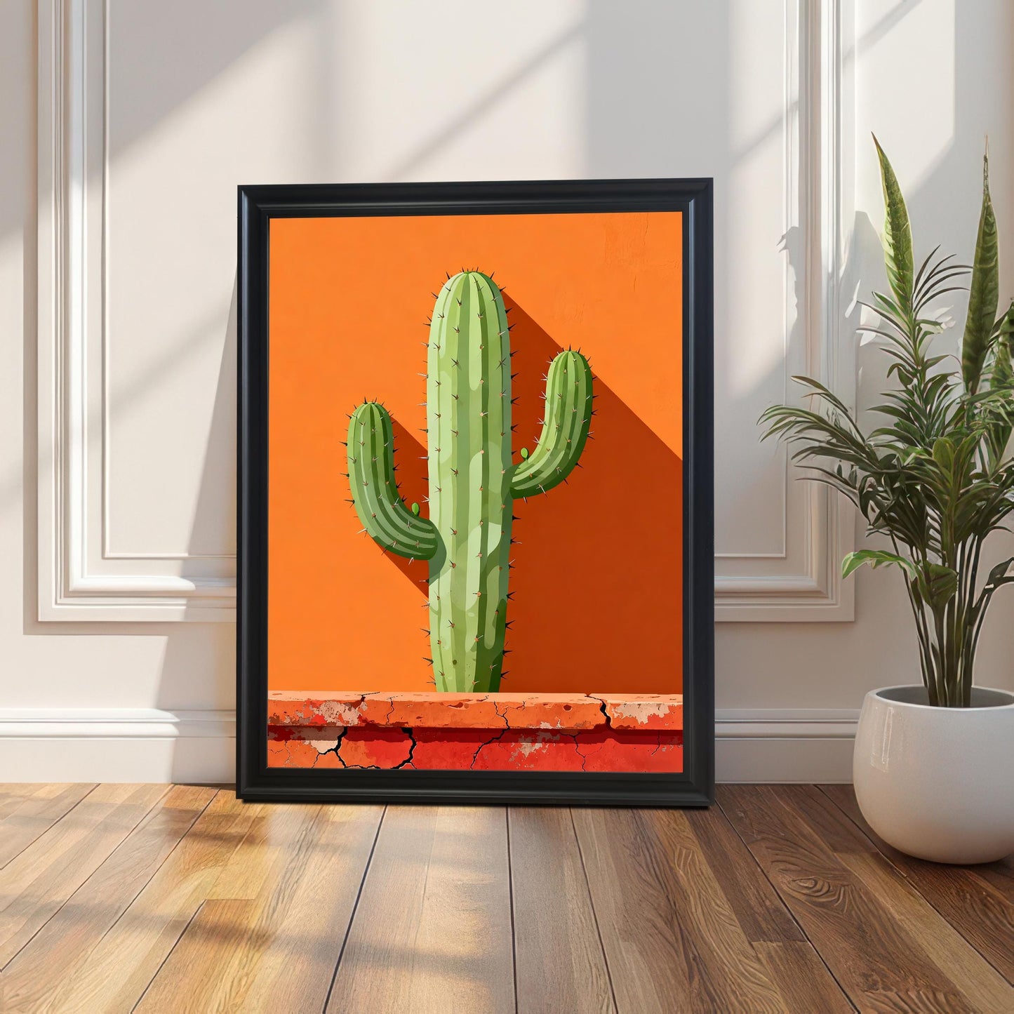 Single framed art print in a Black wood frame leaning against a white wainscoted wall, featuring a minimalist green cactus against a bright orange background.