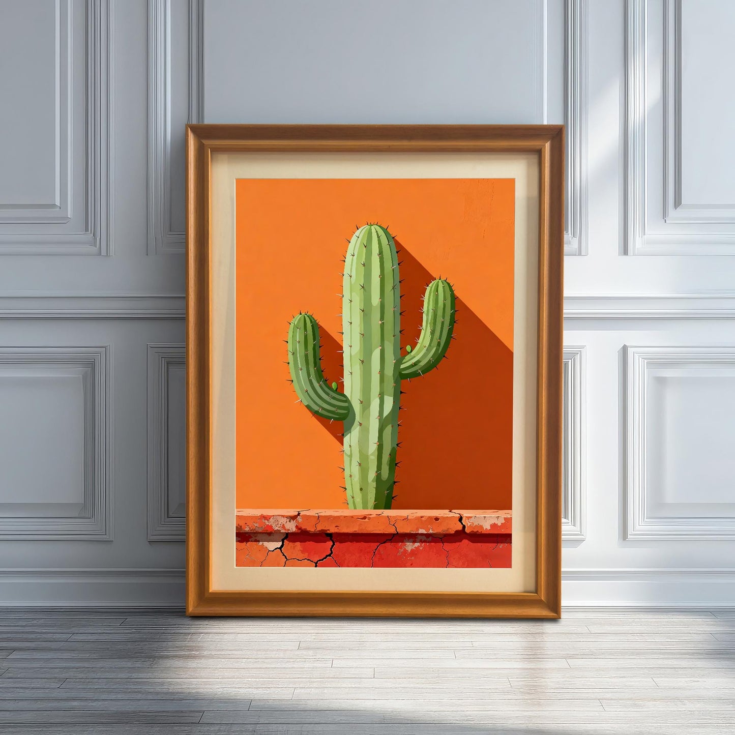 Single framed art print in an Orange wood frame with a mount leaning against a white wainscoted wall, featuring a green cactus against a vibrant orange background with a terracotta base.