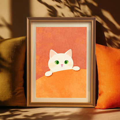 The cute white cat art print in a warm wood frame with a Mount, standing between a gold/olive and a bright orange pillow, highlighting the cozy autumn colors of the artwork. Shadow of leaves or branches is cast onto the wall and pillows.