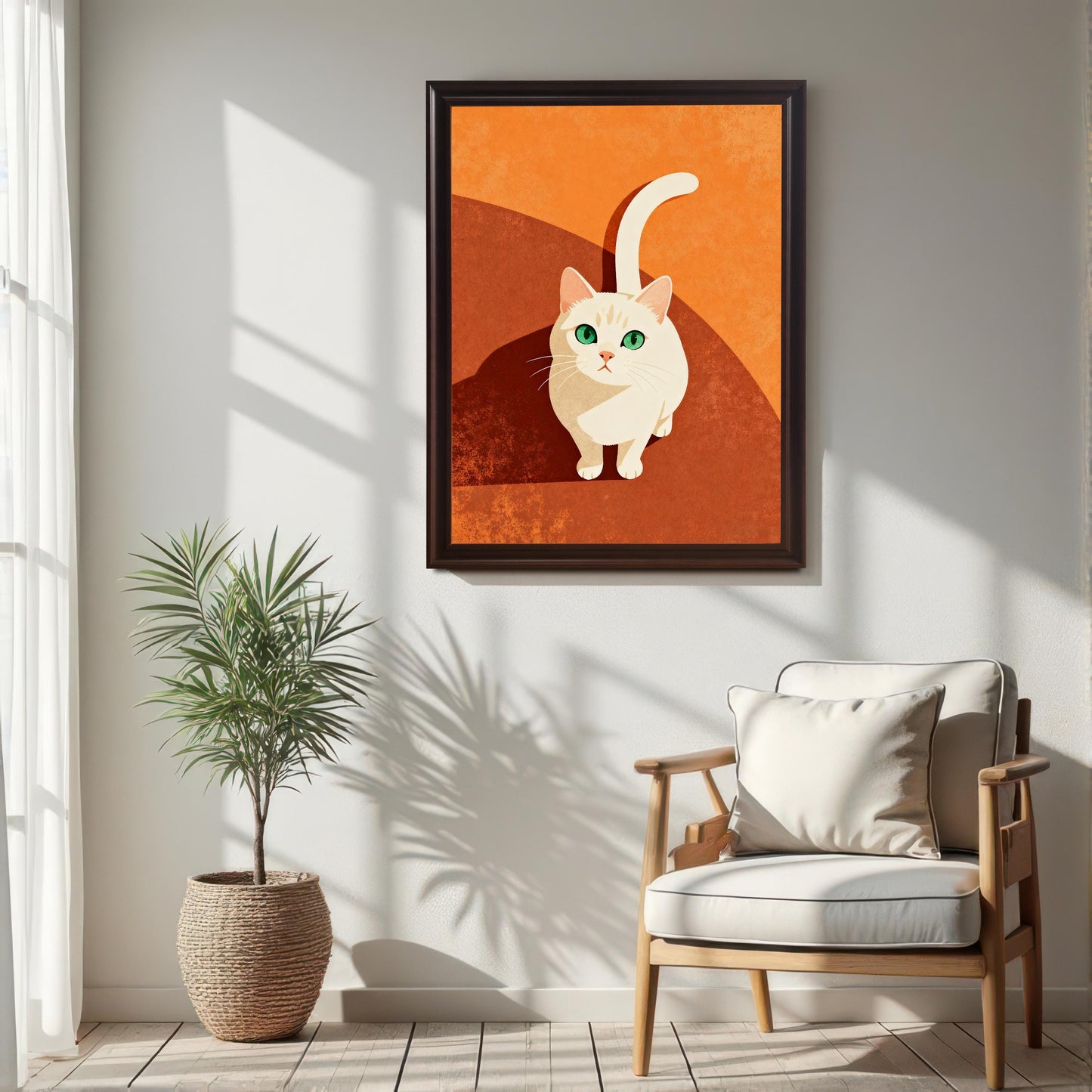 Vertical art print of a white cat looking up, with a striking green eyes, set in an orange and rust-brown color palette, framed in Coffee (dark brown) with No Mount. The art is hung on a white wall in a sunlit room, positioned above a natural wood armchair and beside a potted palm in a woven basket.
