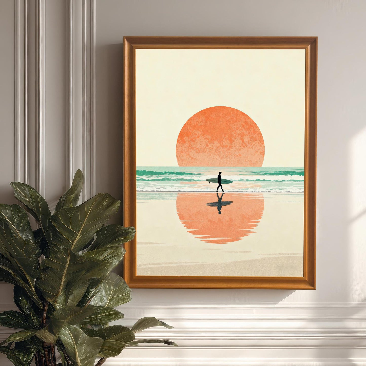 Vertical framed art print of the surfer and the large orange sun, framed in a wood/Orange Frame with No Mount. The art is hung on a white wainscoting wall next to a large potted plant, showcasing the print in a home decor setting.