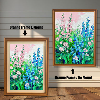 Abstract floral art print featuring pink and blue flowers, shown in two framed options: an Orange Frame with a Mount (lighter border/mat) on the left, and an Orange Frame with No Mount on the right.